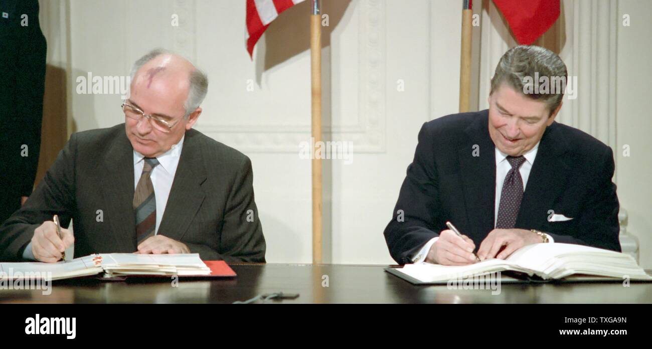 Generalsekretär Michail Gorbatschow (links) und US-Präsident Ronald Reagan (rechts) unterzeichnen den Vertrag Intermediate-Range Nuclear forces (INF). Washington, Weißes Haus, 8. Dezember 1987 Stockfoto