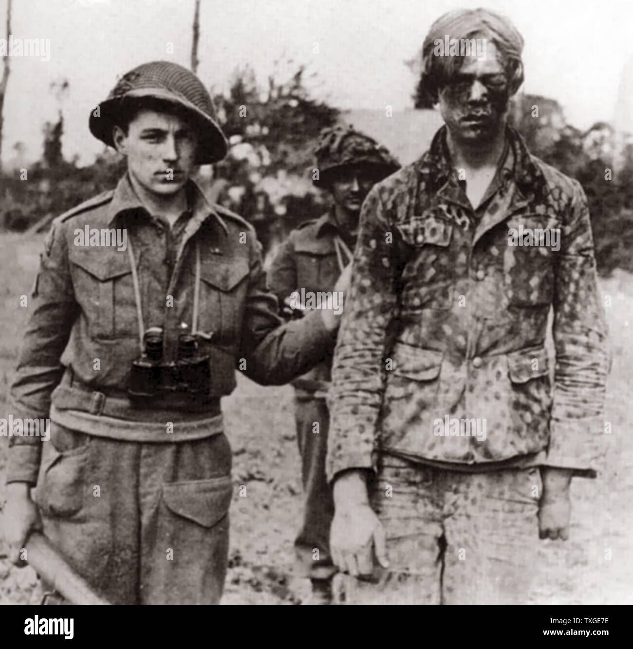 Fotografieren Sie ein erfassten Hitler-Jugend Mitglied mit kanadischen Soldaten. Datiert 1945 Stockfoto