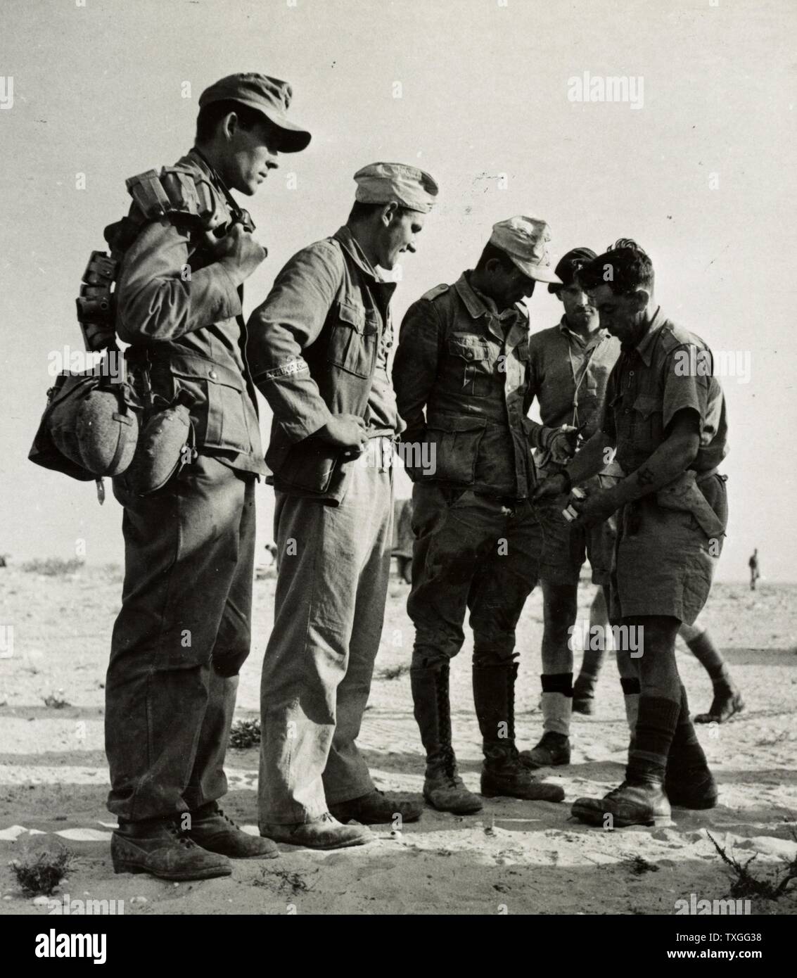 Deutschen Kriegsgefangenen nach gefangen südlich von El Alamein durchsucht wird, sie waren Mitglieder der deutschen Riss Division, 90. Licht div., und trugen das Armband das Afrikakorps Stockfoto