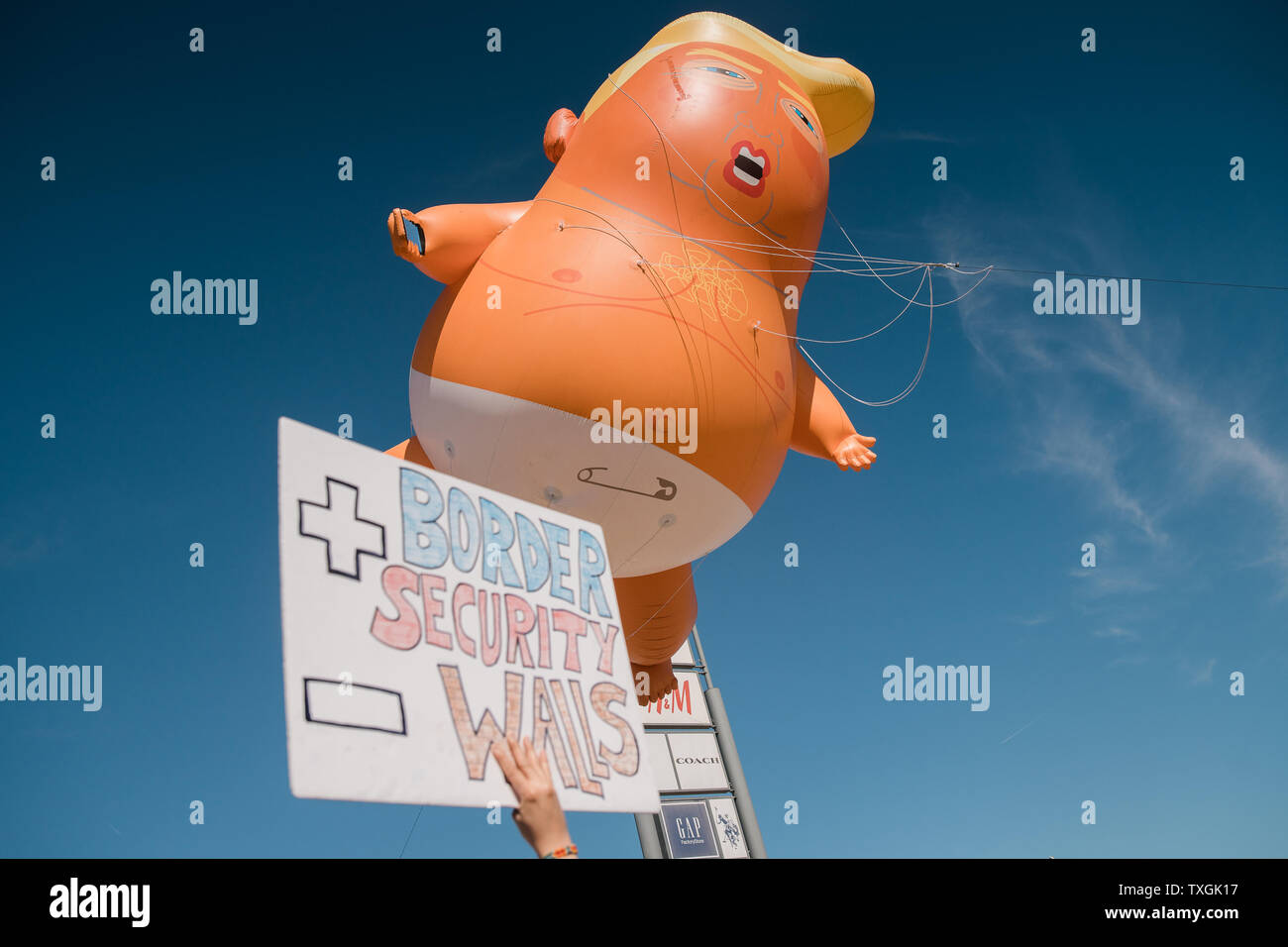 Ein Baby blimp von Präsident Trump schwebt über Demonstranten bei einer Anti-Trumpf-Rallye in Calexico, Kalifornien am 5. April 2019. Präsident Trump besucht die Grenze auf einem Abschnitt der Austausch Fechten zu schauen, ein 30 Fuß Barriere. Foto von Ariana Drehsler/UPI Stockfoto