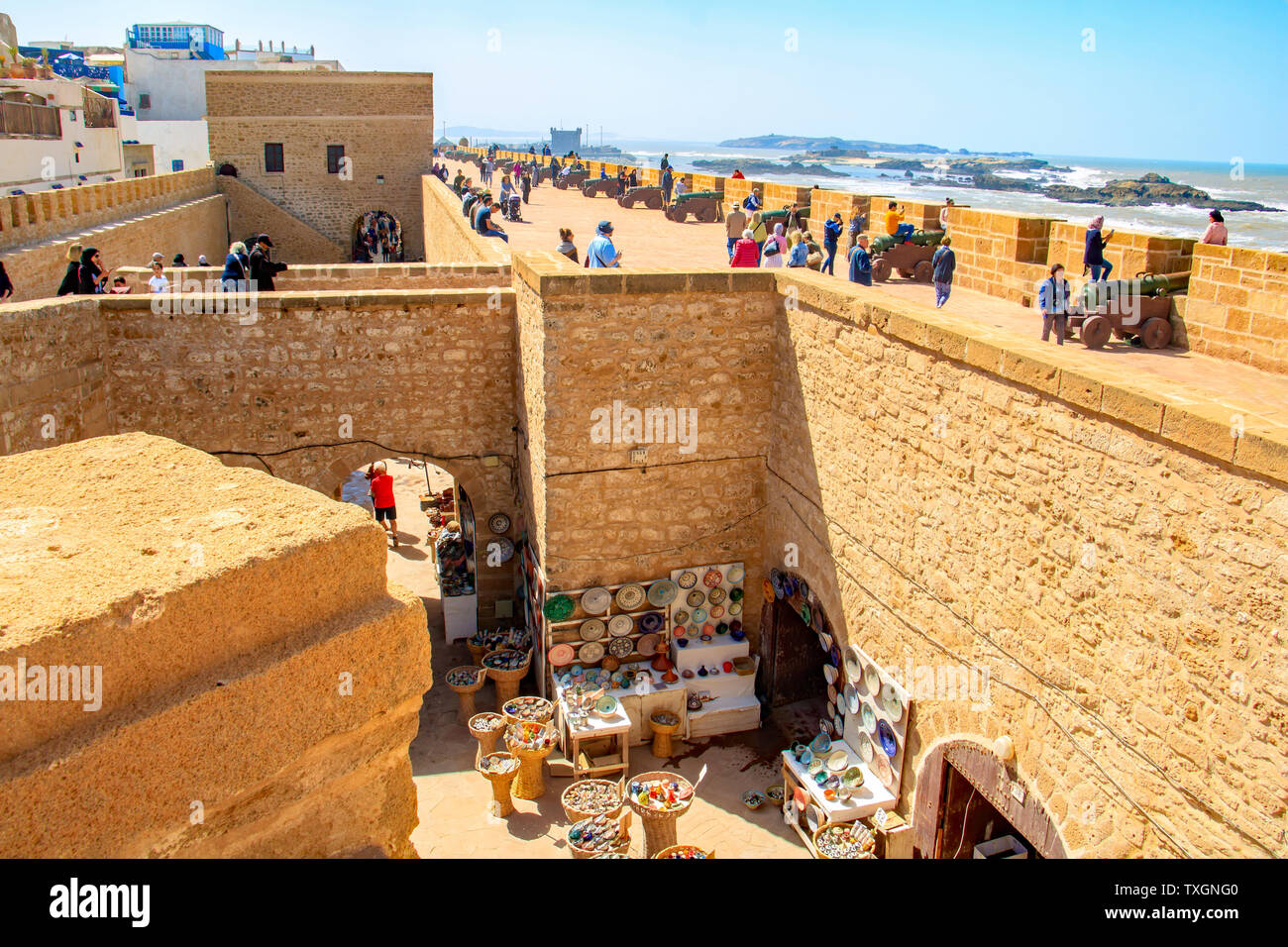 Touristen der Stadtmauer von Essaouira, Marokko klettern. Brass Cannon an den Wänden und es gibt einen herrlichen Blick auf den Atlantischen Ozean. Stockfoto