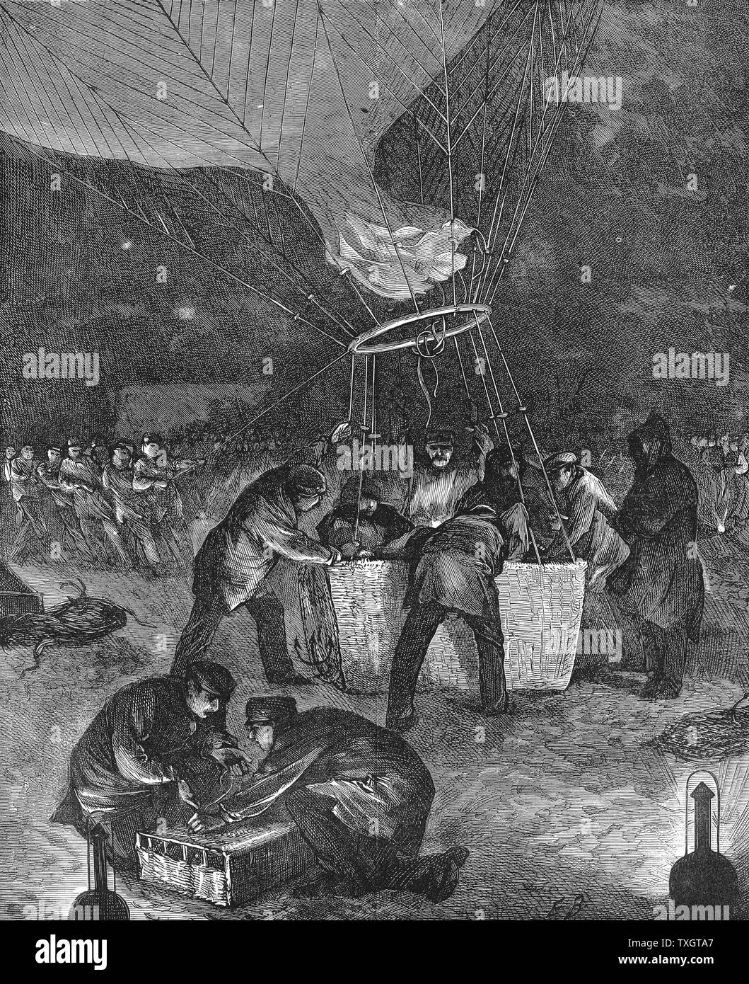 Ballon aufstieg vom Gare du Nord, Paris, nachts, entsendet aus der belagerten Stadt während des Deutsch-Französischen Krieges zu tragen. Im Vordergrund Männer sind Abholung Korb der Brieftauben, die vom Ballon aus der Stadt nehmen würde und das wäre mit Nachrichten veröffentlicht werden zurück nach Paris Holz 1871 Gravur London zu nehmen Stockfoto