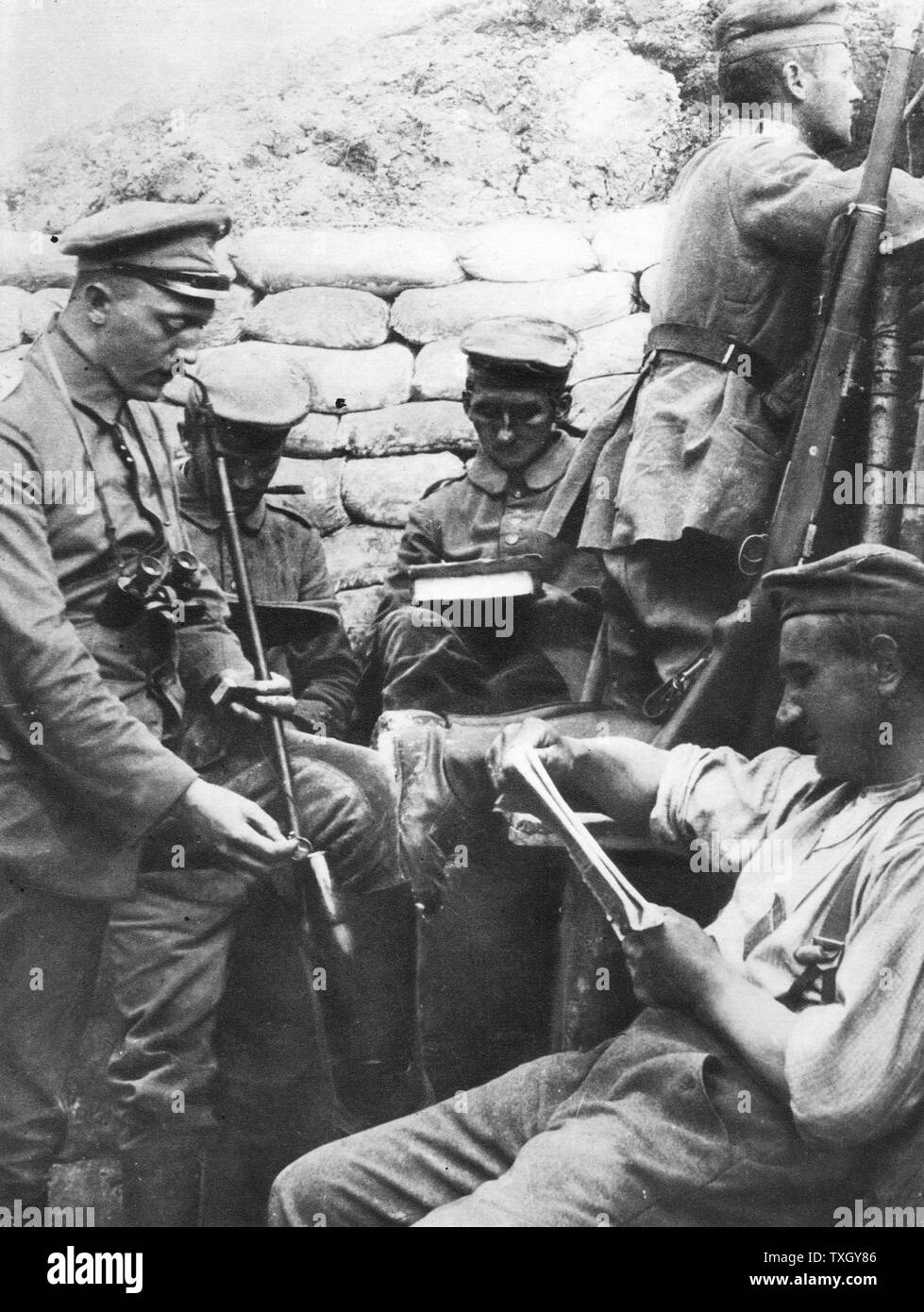 Weltkrieg, Deutsche Soldaten lesen, schreiben und Rauchen in den Schützengräben während einer Ruhepause in Feindseligkeiten Stockfoto