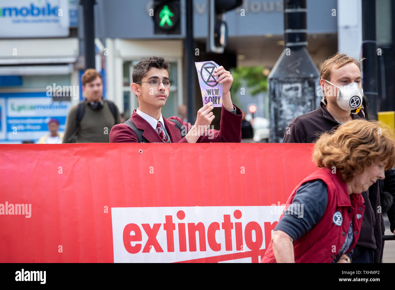 Junge Mann in Schuluniform stoppt Verkehr in Catford, London für Aussterben Rebellion Stockfoto