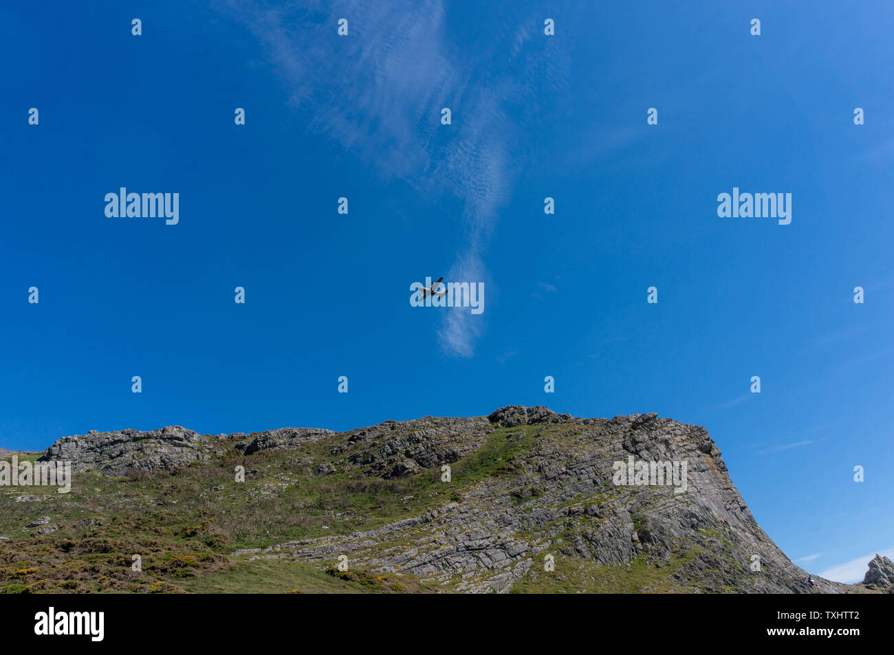 Tief fliegenden Flugzeug in blauer Himmel über Cliff Stockfoto
