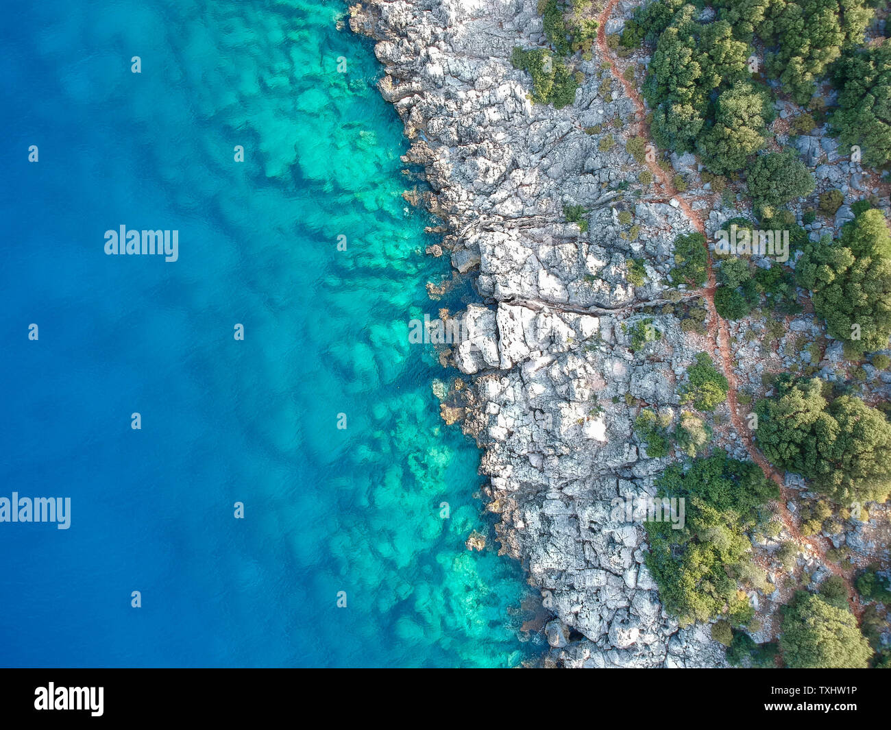 Blick diagonal von oben eine schöne Felsenküste mit klarem, blauen Wasser. Lykischen Weg auf den türkisblauen Küste, Türkei Stockfoto