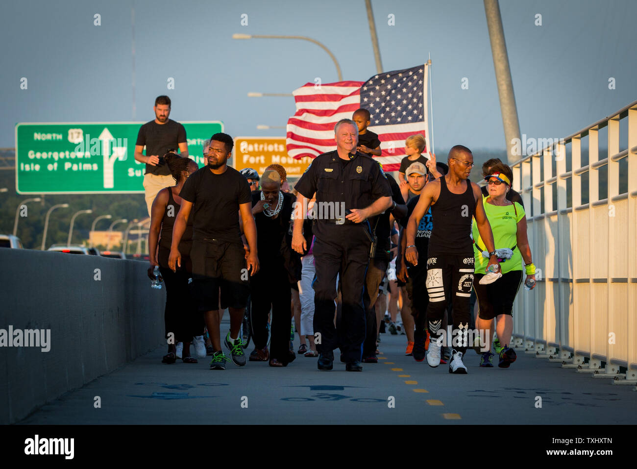 Mt. Angenehme Polizeichef Carl Ritchie (Mitte), Jay Johnson (tank top), Executive Director der offiziellen Schwarzen Leben ausmachen, und andere sich an der Brücke zum Frieden event entlang der Arthur Ravenel Jr. Bridge am 21. Juni 2015 in Charleston, South Carolina. Die Veranstaltung wurde im Gedenken an den neun Menschen, die erschossen wurden und in Emanuel African Methodist Episcopal Church am 17. Juni 2015 ermordet. Ein Verdächtiger, Dylann Dach, 21, war im Zusammenhang mit der Schießerei verhaftet. Foto von Kevin Liles/UPI Stockfoto