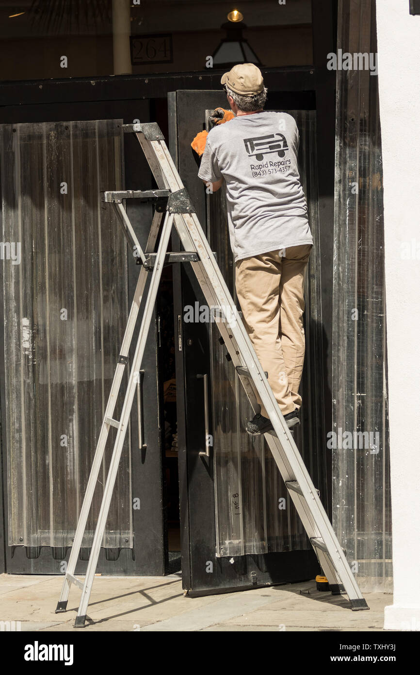 Arbeitnehmer beimessen Hurrikan Fensterläden zu einem Schaufenster auf historischen King Street Shopping District in Vorbereitung auf die Herannahenden Hurrikan Florenz September 11, 2018 in Charleston, South Carolina. Florenz, ein Kategorie 4 Sturm, wird erwartet, um die Küste zwischen Süd und Nord Carolina zu schlagen und konnte der stärkste Sturm auf der Aufzeichnung für die Ostküste der Vereinigten Staaten. Foto von Richard Ellis/UPI Stockfoto