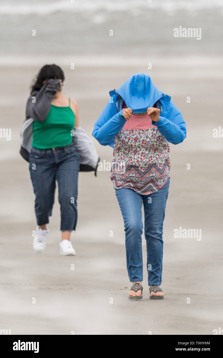 Anwohner die ihre Gesichter gegen Blasen von Sand am Strand, die als deklassiertes Tropischer Sturm Florenz erreicht den Charleston Bereich September 14, 2018 in Isle of Palms, South Carolina. Der Sturm, der die Küste North Carolinas hit schnell geschwächt zu einem tropischen Sturm als kreuzt sie South Carolina. Foto von Richard Ellis/UPI Stockfoto