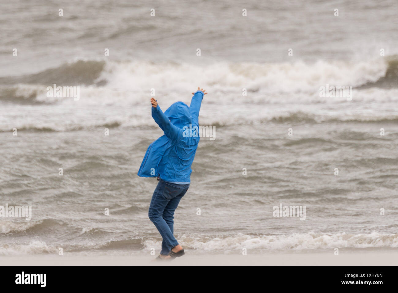 Ein anwohner Spaziergänge nach hinten als kämpft sie Blasen von Sand am Strand, die als deklassiertes Tropischer Sturm Florenz der Charleston Bereich September 14, 2018 in Isle of Palms, South Carolina erreicht. Der Sturm, der die Küste North Carolinas hit schnell geschwächt zu einem tropischen Sturm als kreuzt sie South Carolina. Foto von Richard Ellis/UPI Stockfoto