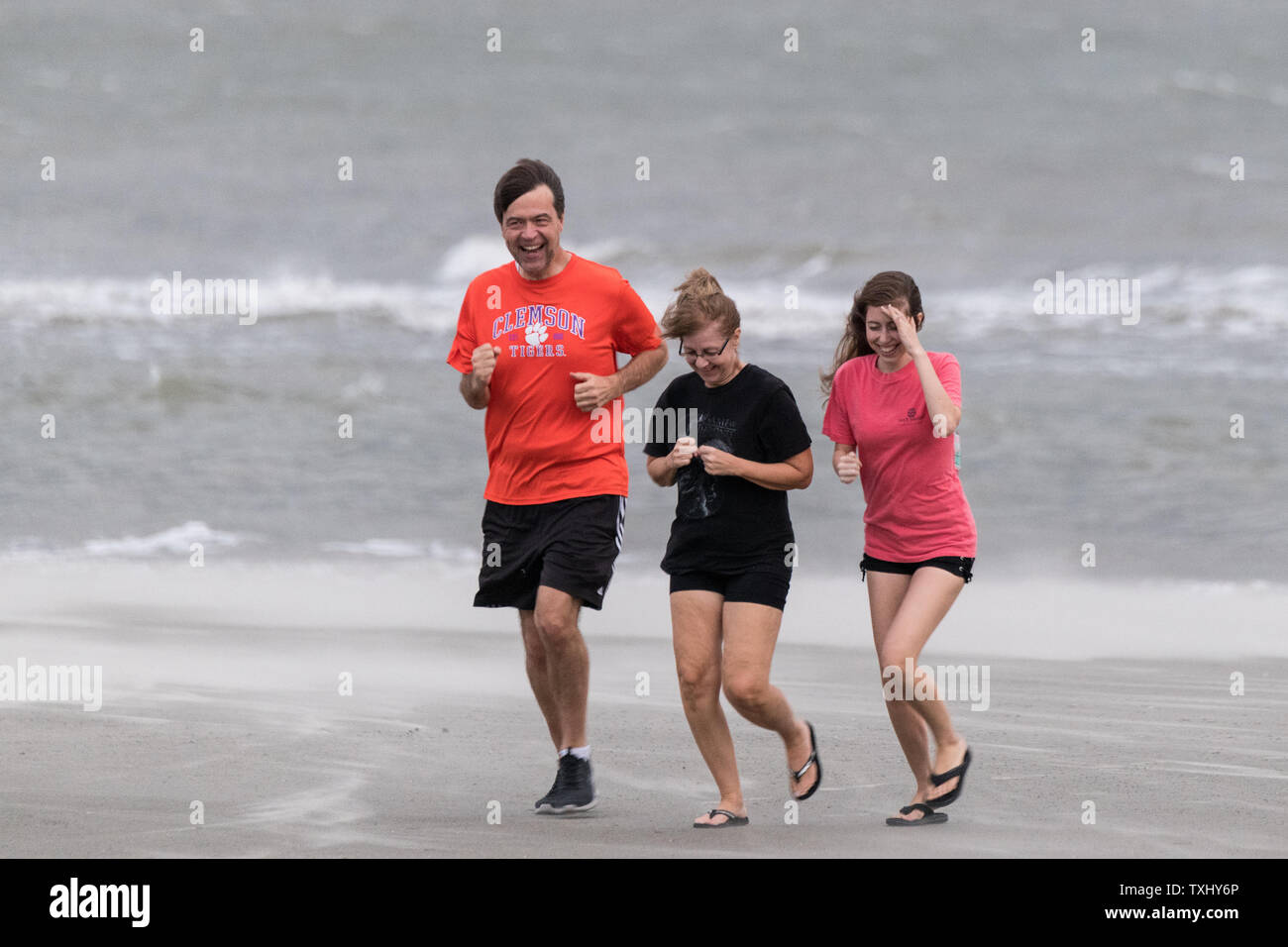 Lokaler Bewohner laufen am Strand bei böigem Wind und Regen als deklassiertes Tropischer Sturm Florenz erreicht den Charleston Bereich September 14, 2018 in Isle of Palms, South Carolina. Der Sturm, der die Küste North Carolinas hit schnell geschwächt zu einem tropischen Sturm als kreuzt sie South Carolina. Foto von Richard Ellis/UPI Stockfoto