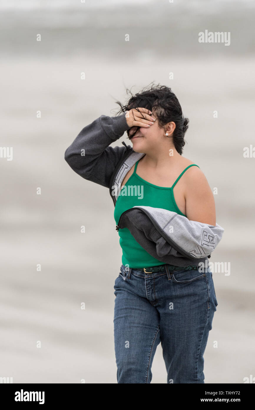 Ein anwohner Abdeckung ihr Gesicht gegen das Blasen von Sand am Strand, die als deklassiertes Tropischer Sturm Florenz der Charleston Bereich September 14, 2018 in Isle of Palms, South Carolina erreicht. Der Sturm, der die Küste North Carolinas hit schnell geschwächt zu einem tropischen Sturm als kreuzt sie South Carolina. Foto von Richard Ellis/UPI Stockfoto