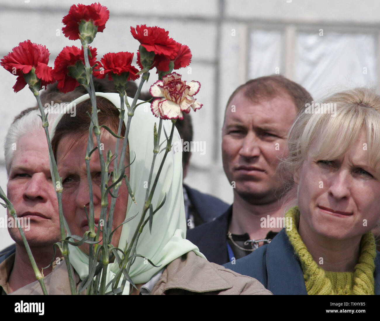 Hält eine Frau Blumen, wie Sie und andere Menschen an der Gedenkfeier Kundgebung für diejenigen, die während und nach der Reaktorkatastrophe von Tschernobyl in der Nähe, das Kernkraftwerk Tschernobyl am 26. April 2006 starb. Heute Ukraine markiert den 20. Jahrestag der Reaktorkatastrophe von Tschernobyl, wenn der vierte Reaktor in Tschernobyl explodierte, die Verbreitung einer radioaktiven Wolke in der ehemaligen Sowjetunion. (UPI Foto/Sergey Starostenko) Stockfoto