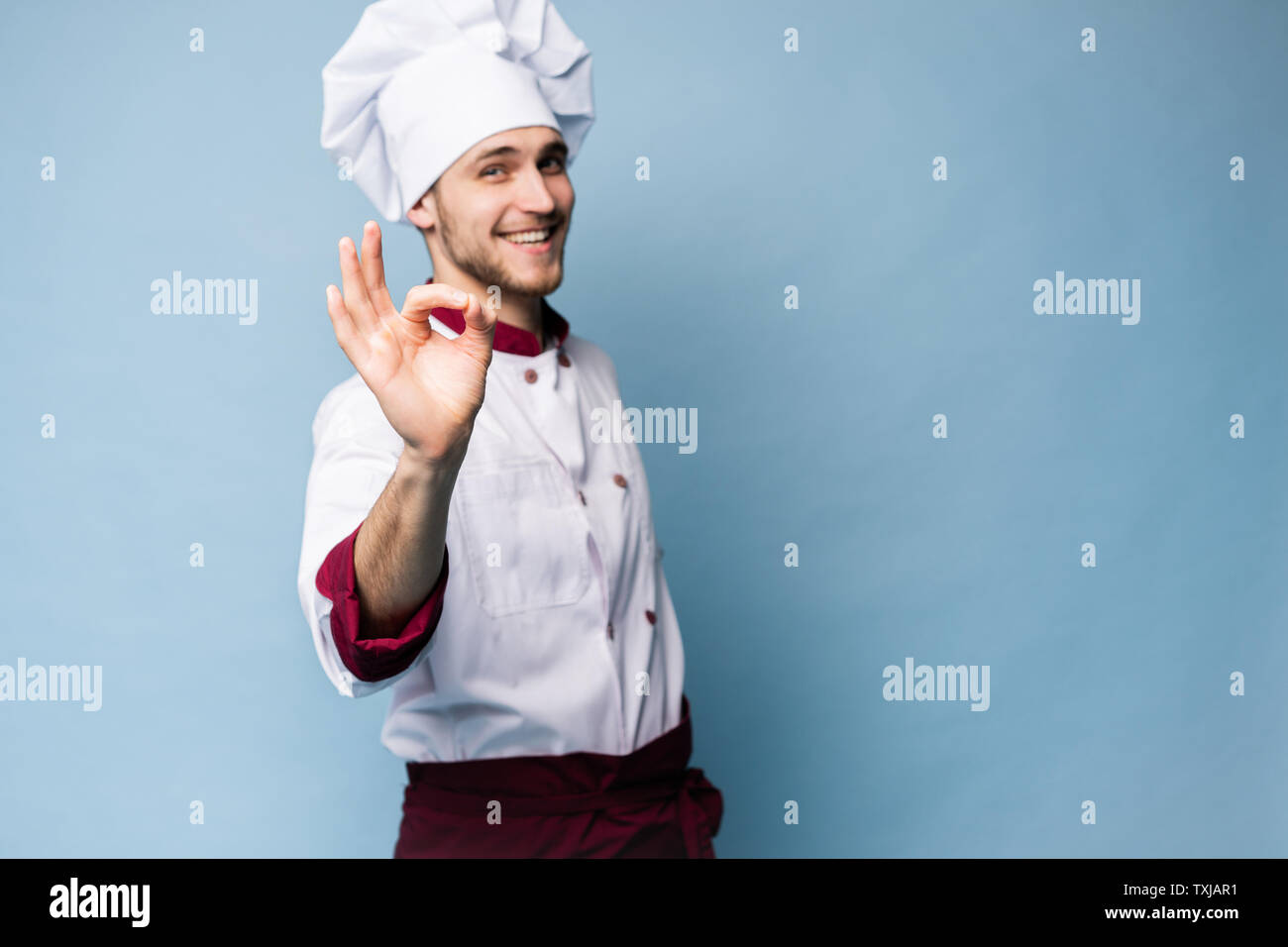 Positive Professionelle happy Mann Koch Übersicht lecker ok Zeichen isoliert auf Hellblau. Stockfoto