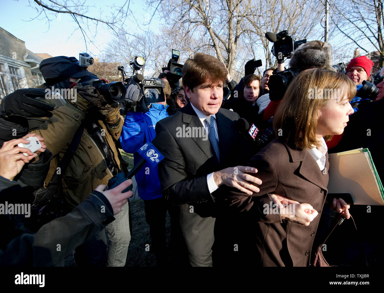 Ehemalige Illinois reg. Rod Blagojevich (C) wird von seiner Frau Patti geführt, wie sie ihr Haus verlassen zu Bundesgerichtshof für eine urteilsverkündung am 7. Dezember in Chicago 2011. Staatsanwälte fordern einen Satz von 15 bis 20 Jahren als Strafe für Blagojevich die Überzeugung am 18 kriminelle zählt im Zusammenhang mit der versuchten Verkauf eines US-Senat Sitz, illegale shakedowns für Kampagne finanziert und Lügen zu Bundesmittel UPI/Brian Kersey Stockfoto
