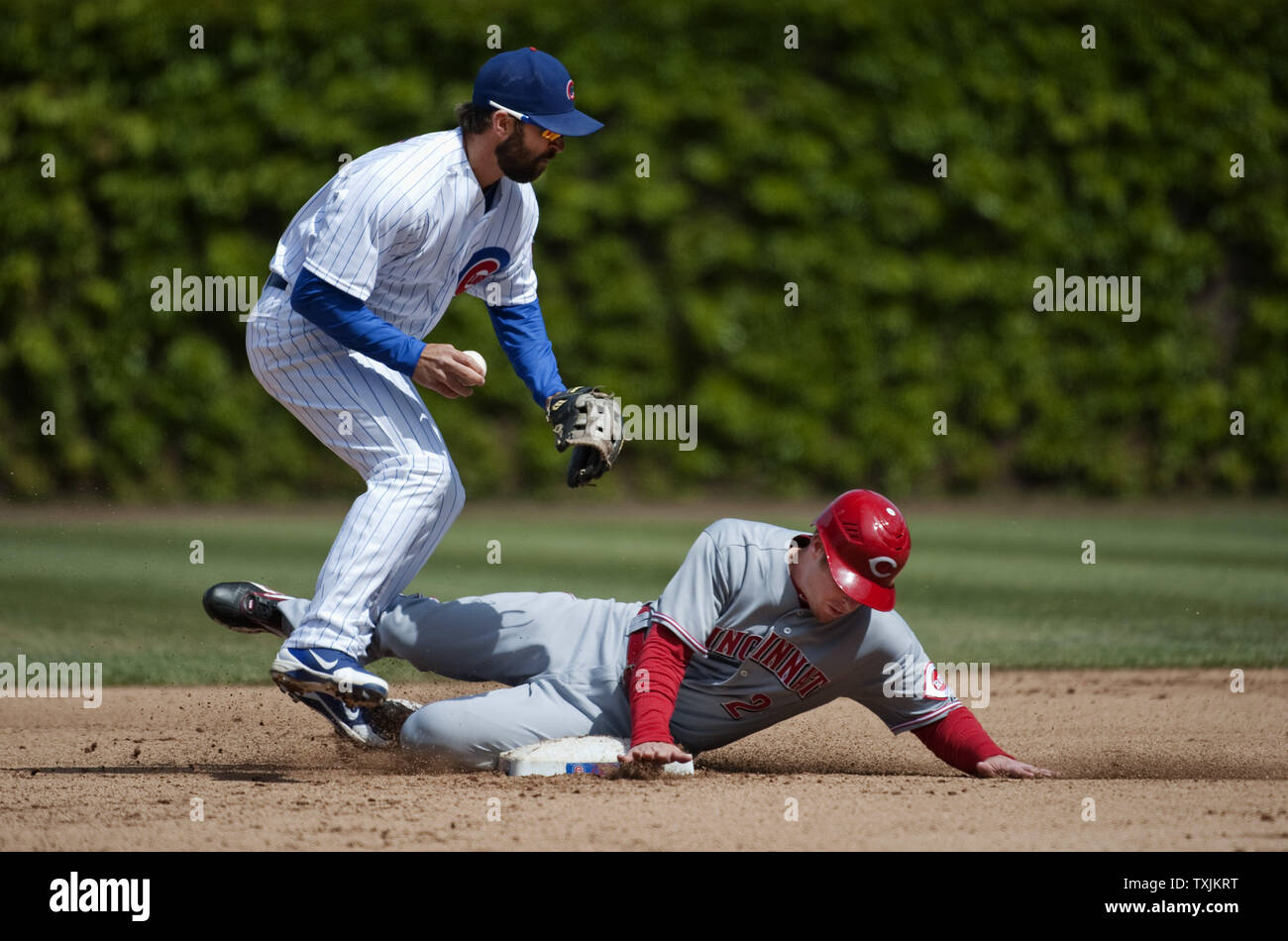 Cincinnati Reds' Zack Cozart (R) Folien in Chicago Cubs zweiter Basisspieler Blake DeWitt bis ein doppeltes Spiel auf einem Boden Kugel durch Rottöne zeichnete Stubbs im vierten Inning schlug bei Wrigley Field am 22. April in Chicago 2012 zu brechen. UPI/Brian Kersey Stockfoto