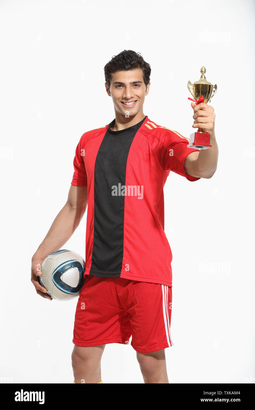 Porträt eines Mannes, der einen Fußball hält und zeigt Trophäe Stockfoto