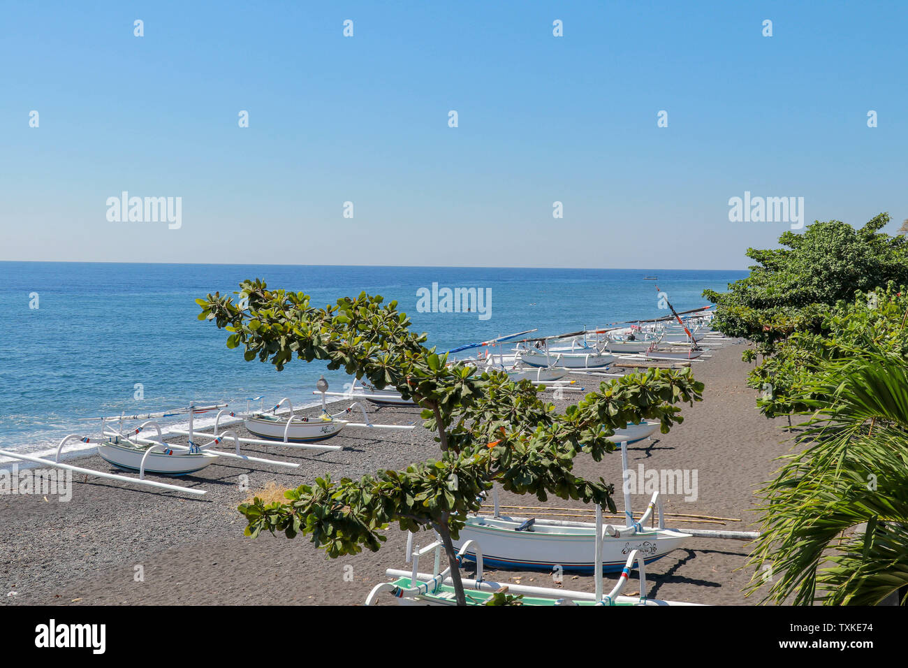 Schwarzen vulkanischen Sand Strand in der Nähe von Agung Vulkan. Tropisches Paradies mit Palmen und majestätischen Vulkan im Hintergrund. Blick von oben. Stockfoto