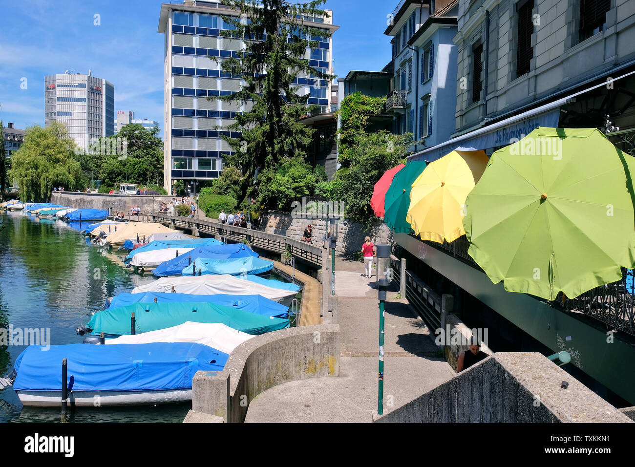 Schanzengraben Promenade mit überdachte Boote und bunten Sonnenschirmen an Cafe Bar Le Raymond Bar, Zürich. Stockfoto