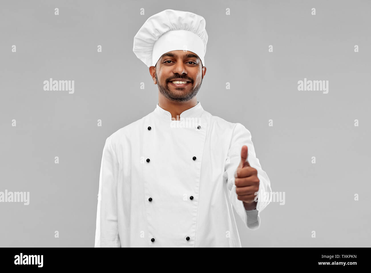 Gerne männliche indische Koch in Toque, Daumen hoch Stockfoto