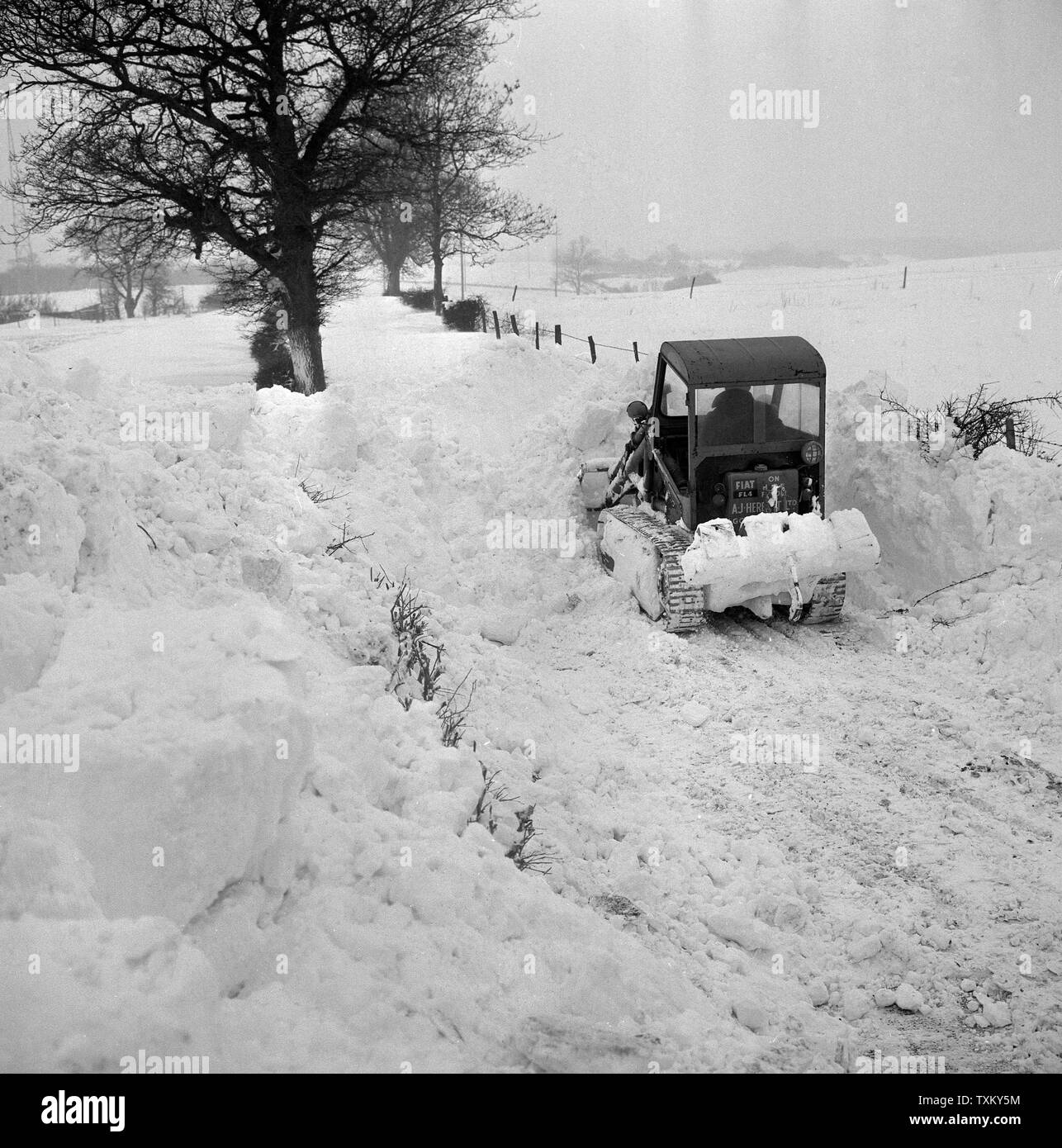 Eine mechanische Schaufel gräbt ein Weg durch die schneeverwehungen zu Radio Station des BBC bei Tatsfield, Kent. Viele Straßen in der Grafschaft noch unpassierbar nach dem Wochenende Blizzard, die den südlichen Teil von England gefegt. Stockfoto