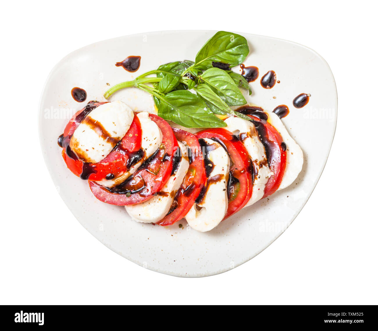 Italienische Küche Insalata Caprese (Caprese) - Blick von oben auf die in Scheiben geschnittenen Mozzarella und Tomaten mit Basilikum Zweig, gewürzt durch Olivenöl und Balsamico Stockfoto