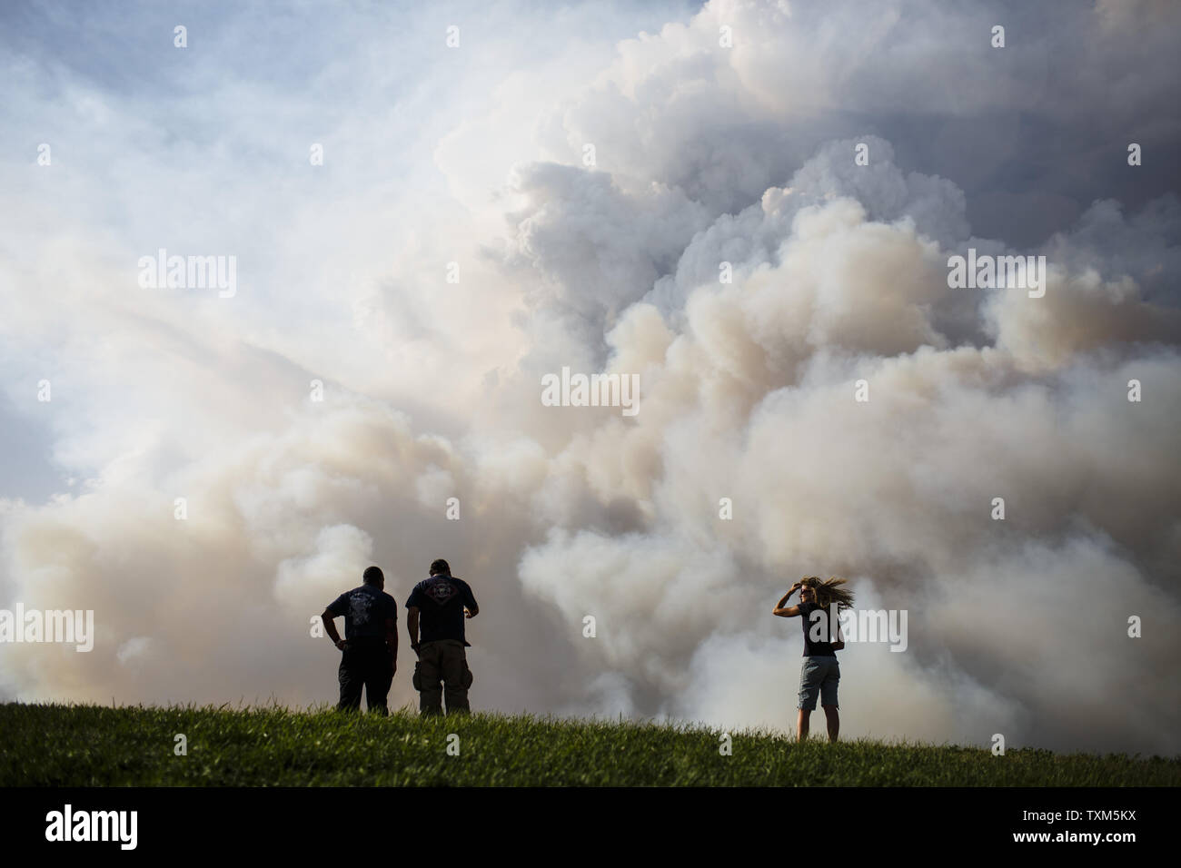 Denise Bockman (rechts) von Colorado Springs und zwei nicht identifizierte Feuerwehrleute aus dem Colorado Springs Utility Fire Team beobachten die Waldo Canyon Feuer aus dem Command Center in Coronado High School in Colorado Springs, Colorado am 26. Juni 2012. Das Feuer explodierte am Dienstag nachmittag nach drastischen Verschiebungen im Wind das Feuer in Ausläufern Nachbarschaften von Colorado Springs geschoben und zerstörte zahlreiche Häuser. UPI/Trevor Brown Jr. Stockfoto
