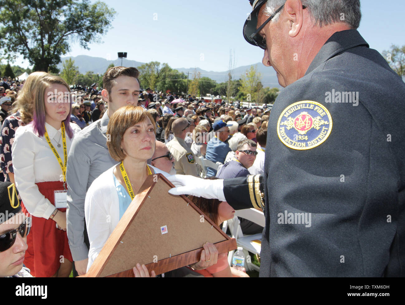 Ein zeremonielles Flag auf die Familie des späten Mehville vorgestellt, Missouri fire fighter Joseph S. Schmidt jr., während der Internationale Verband der Feuerwehrleute jährliche Gefallen Fire Fighter Gedenkfeier in Colorado Springs am 19. September 2015. Fast 300 Namen der Feuerwehrleute, die in der Linie der Aufgabe innerhalb des letzten Jahres gestorben sind, wurden gelesen. Foto von Bill Greenblatt/UPI Stockfoto