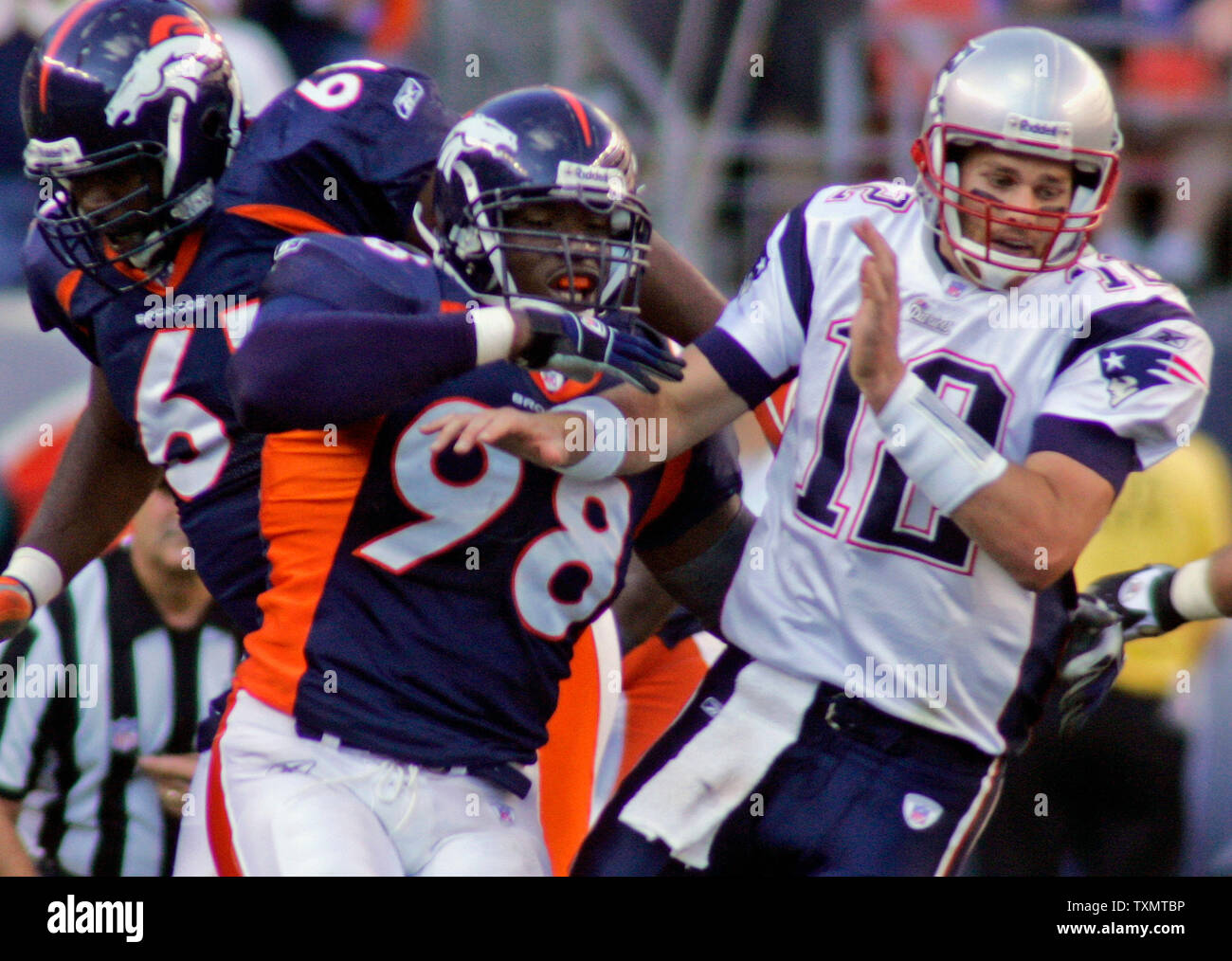 New England Patriots Quarterback Tom Brady (R) wird von den Denver Broncos defensive Ende Courtney Brown auf einem Pass rush bei Invesco Field in Denver, CO am 16. Oktober 2005 gestoßen. Broncos defensiver Gerard Warren auf das Spiel unterstützt. Denver beat New England 28-20. (UPI Foto/Gary C. Caskey) Stockfoto