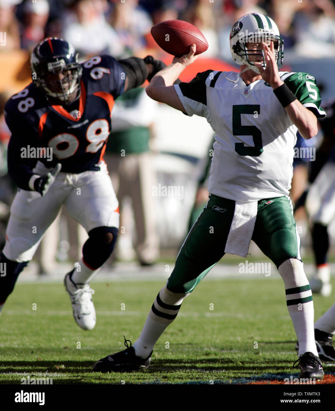 New York Jets quarterback Brooks Bollinger (R) wirft unter dem Druck der Denver Broncos defensive Ende Courtney Brown (L) an Invesco Field in Denver Sonntag November 20, 2005. Denver beat New York 27-0. (UPI Foto/Gary C. Caskey) Stockfoto
