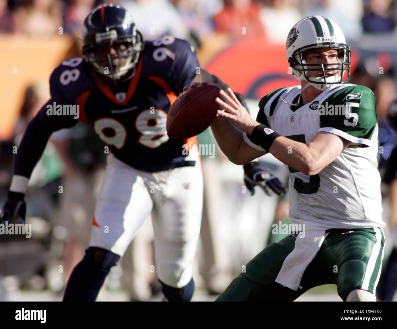 New York Jets quarterback Brooks Bollinger (R) wirft, während von den Denver Broncos defensive Ende Courtney Brown (L) an Invesco Field in Denver, 20. November 2005 stürzte. Denver beat New York 27-0. (UPI Foto/Gary C. Caskey) Stockfoto