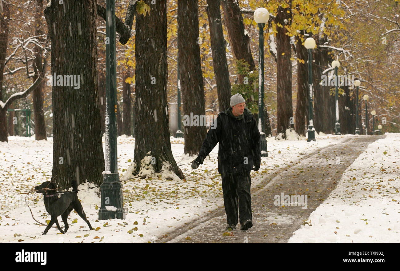 Anthony Hanneken und seinem Hund einen Spaziergang durch Cheeseman Park nach einer Nacht im Schneesturm in Denver, 26. Oktober 2006. (UPI Foto/Gary C. Caskey) Stockfoto