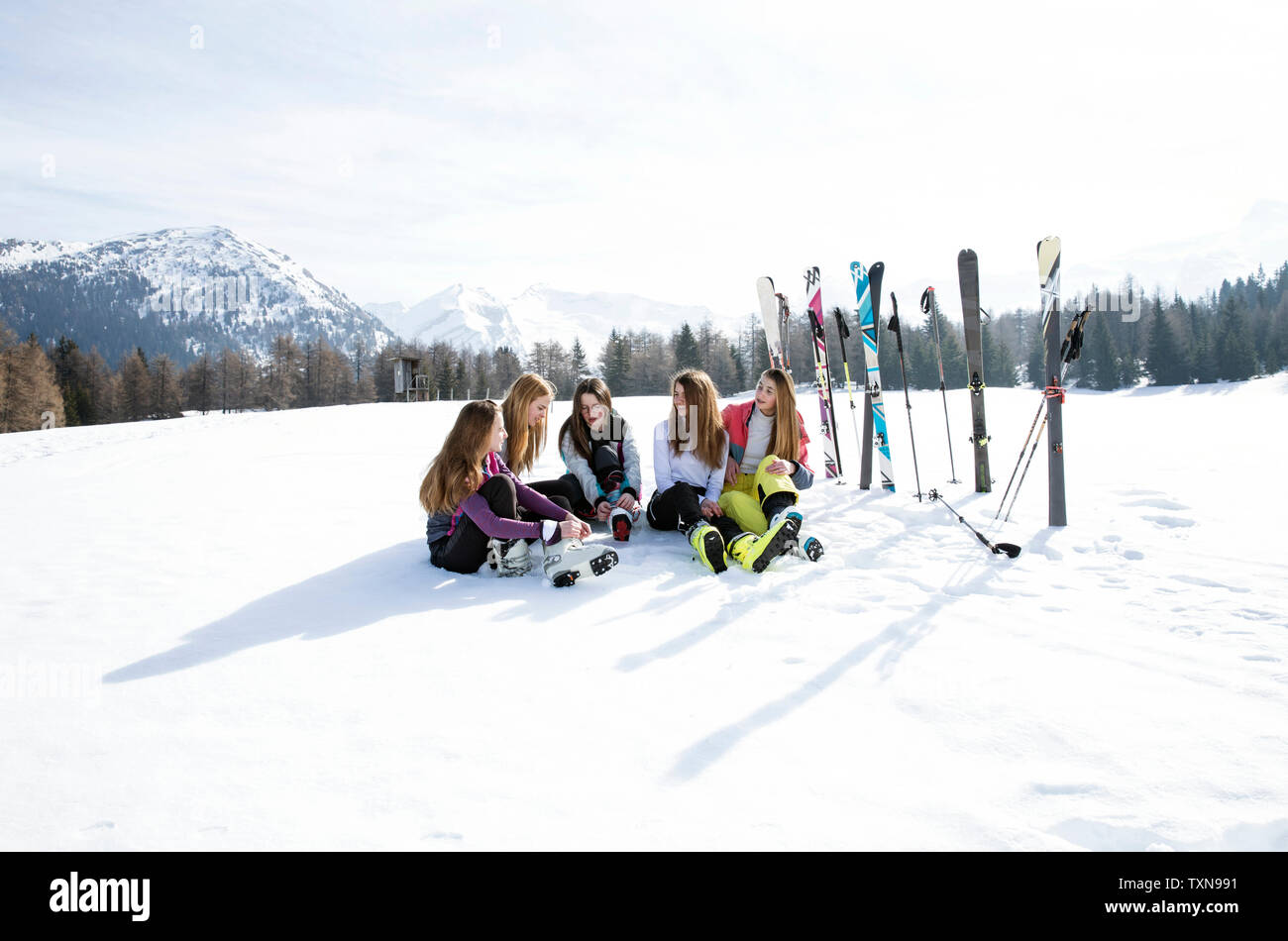 5 Jugendmädchen Skifahrer sitzen in der schneebedeckten Landschaft, Tirol, Steiermark, Österreich Stockfoto