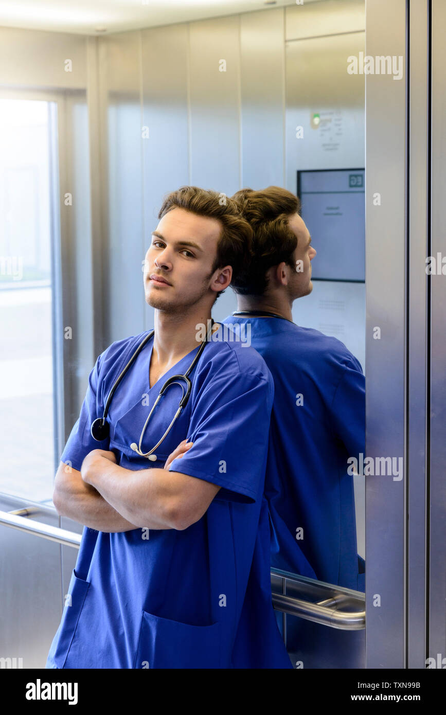 Junge männliche junior Arzt im Krankenhaus Aufzug, Porträt Stockfoto