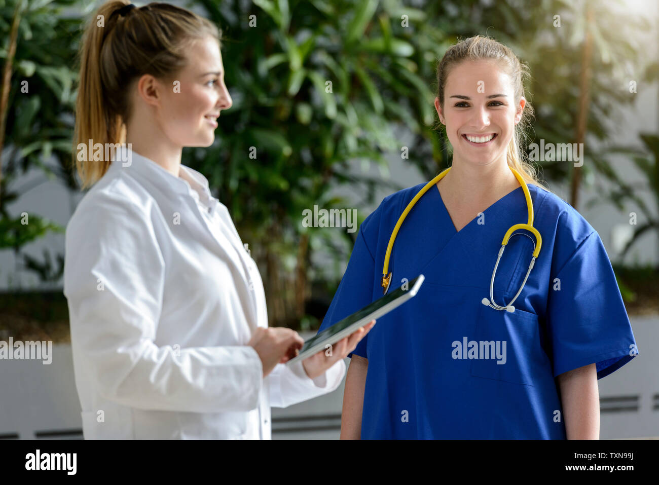 Zwei weibliche Ärzte mit digitalen Tablet außerhalb des Spitals, Porträt Stockfoto