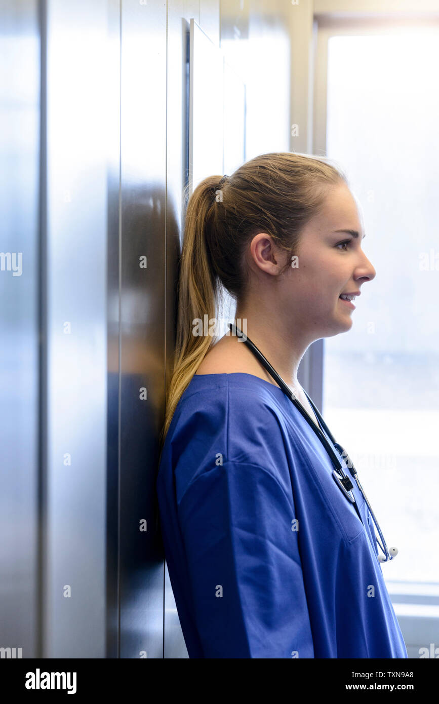 Junge weibliche junior Arzt im Krankenhaus Aufzug Stockfoto