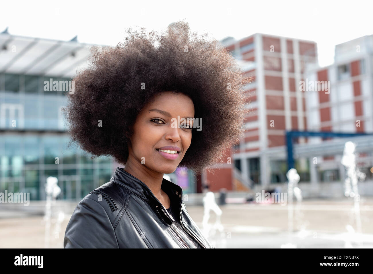 Junge Frau mit afro Haar auf der Stadt Halle, Porträt Stockfoto