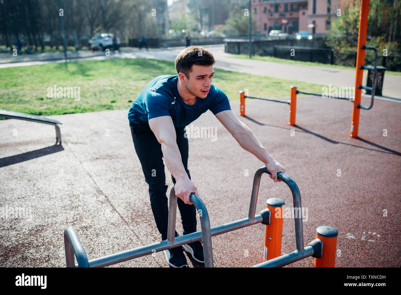 Calisthenics im Fitnessbereich im Freien, jungen Mann Vorbereitung übung Ausrüstung zu verwenden Stockfoto