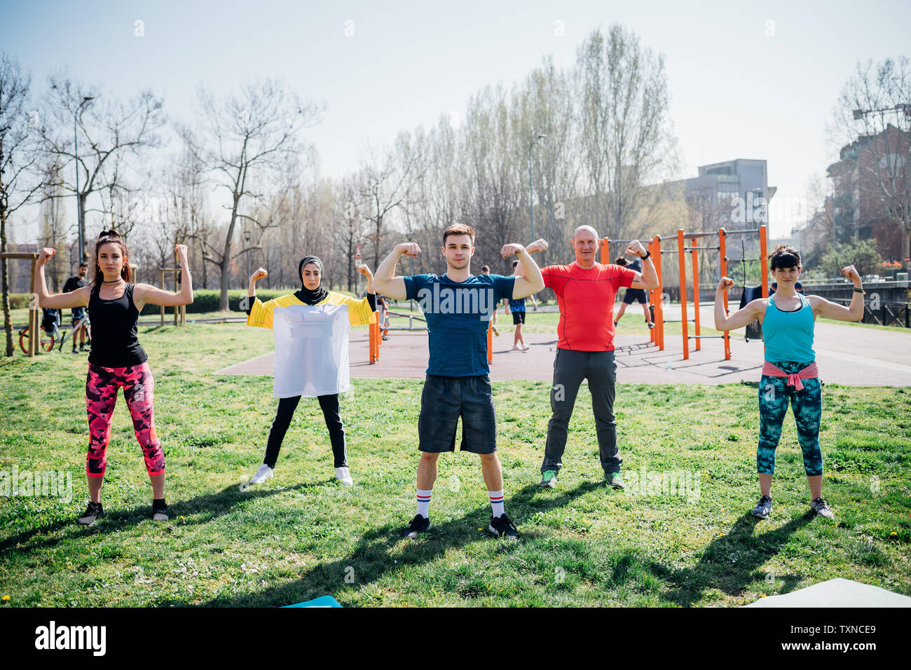 Calisthenics Klasse im Fitnessbereich im Freien, Frauen und Männer ihre arm Muskeln Stockfoto