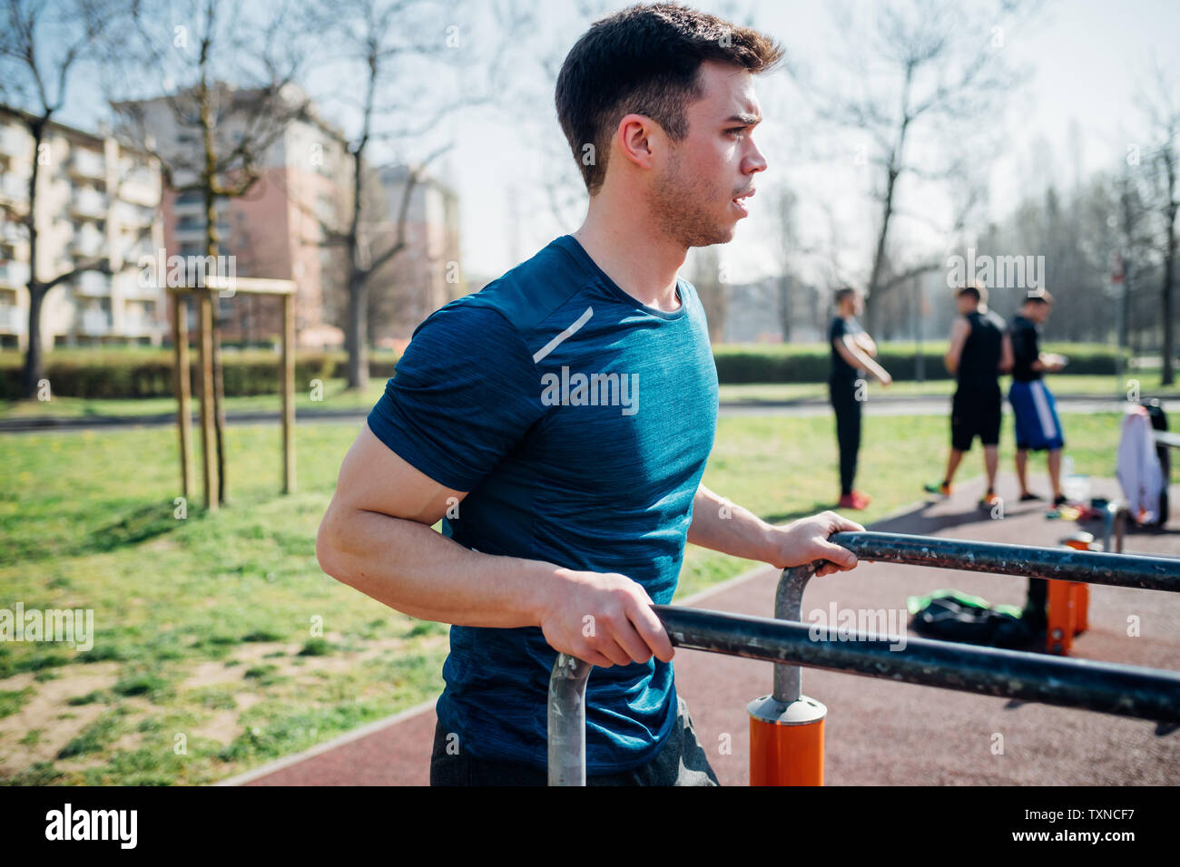 Calisthenics im Fitnessbereich im Freien, jungen Mann Vorbereitung parallel Bars zu verwenden Stockfoto