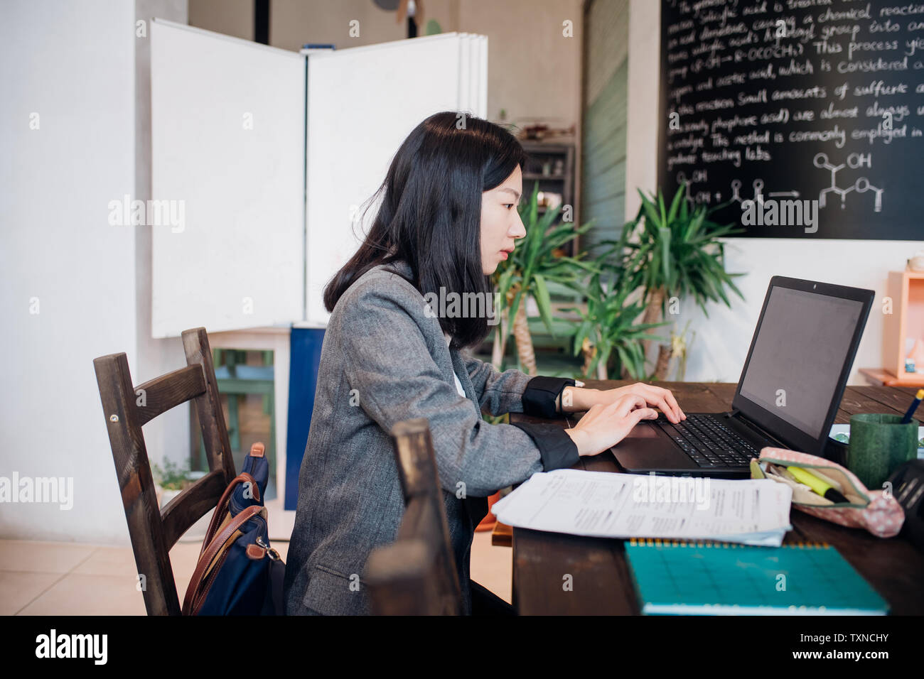 Junge Geschäftsfrau, die remote Arbeiten am Laptop im Cafe Tabelle Stockfoto