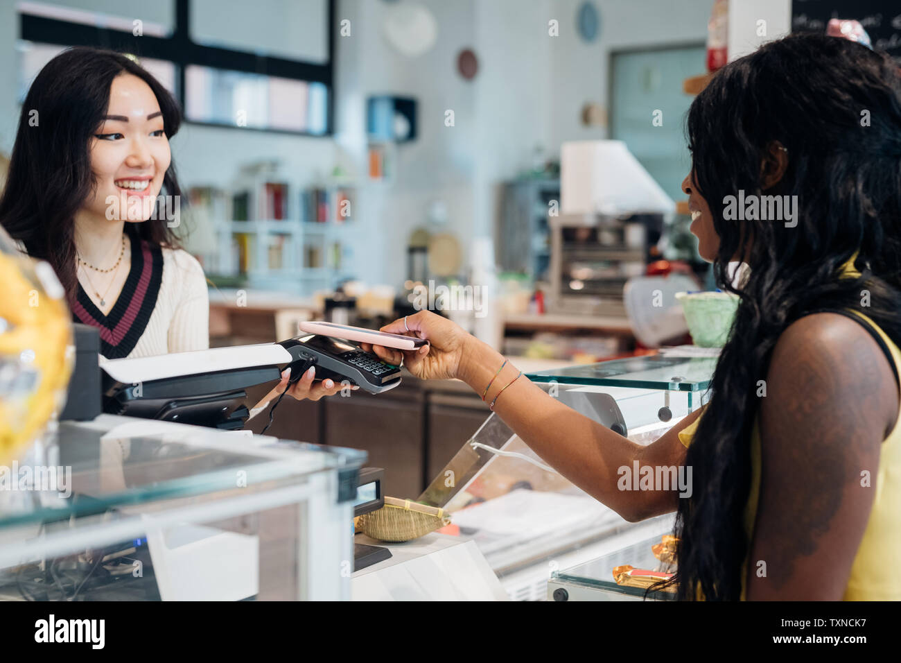 Junge Geschäftsfrau, Smartphone Zahlung im Cafe Zähler Stockfoto