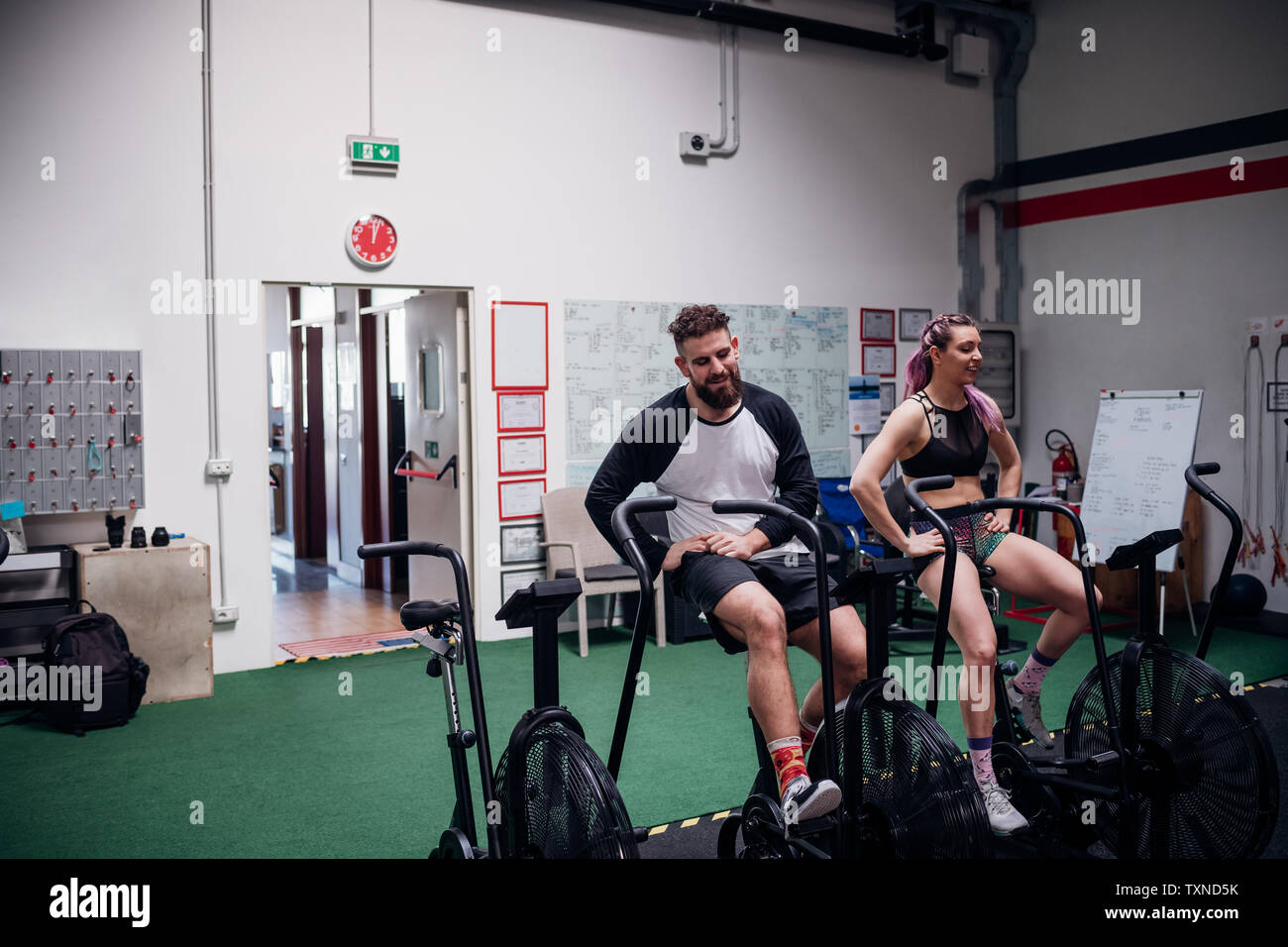 Erschöpft junge Frau und Mann training zusammen auf gym Heimtrainer, eine Pause Stockfoto