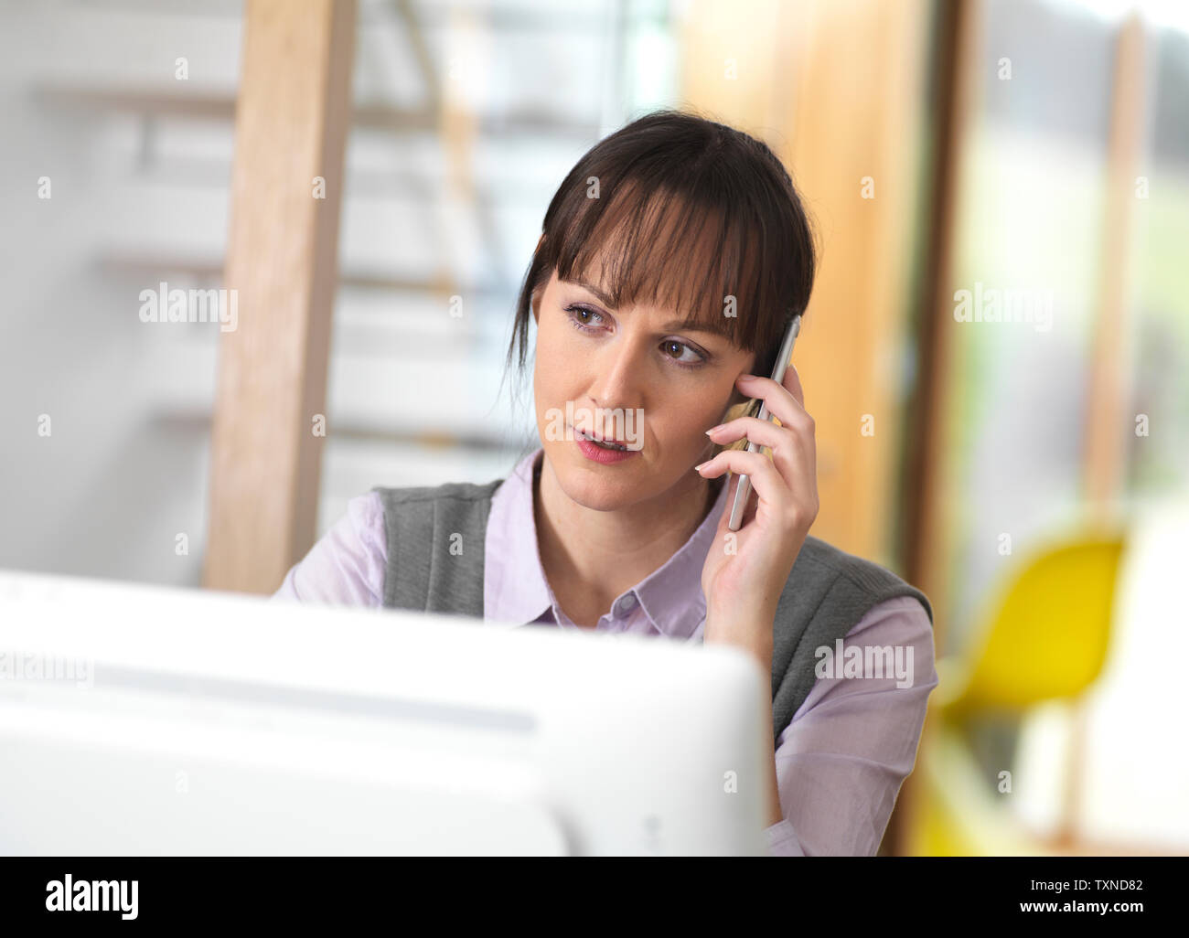 Frau im Gespräch durch ein Geschäft am Telefon Stockfoto