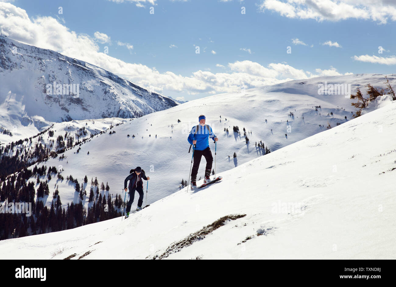 Reifen Skifahren paar bewegte sich schneebedeckte Berge, Steiermark, Tirol, Österreich Stockfoto