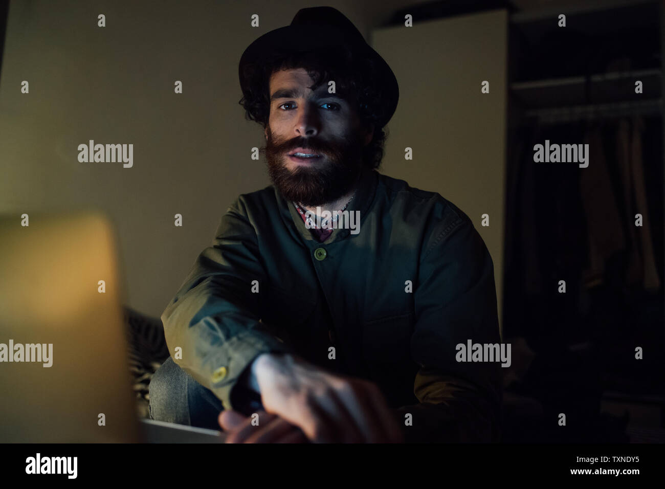 Junger Mann mit Laptop zu Hause Bärtigen Stockfoto