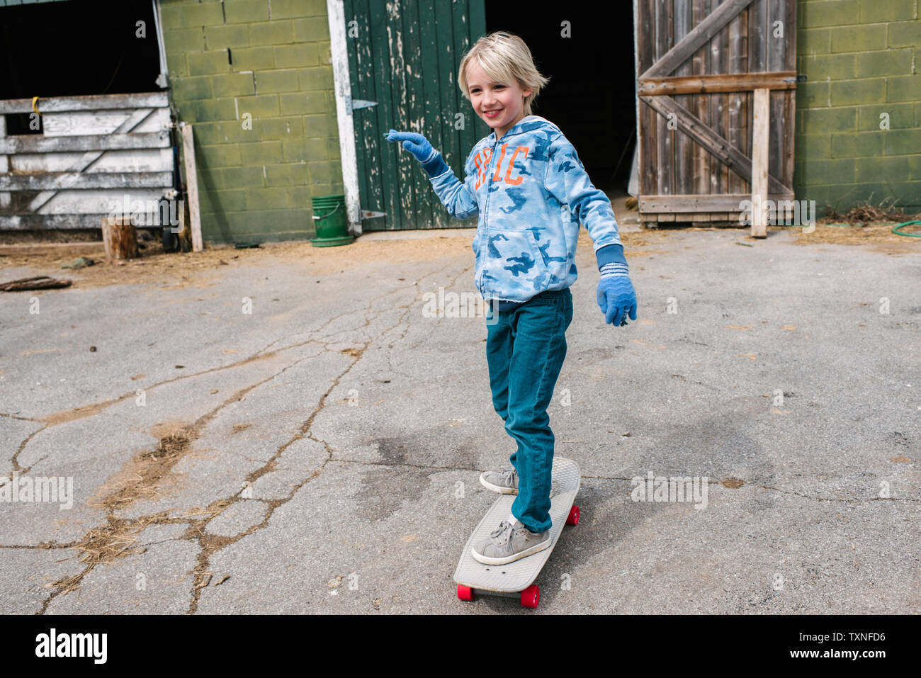 Blonde junge Skateboarding in Hof Stockfoto