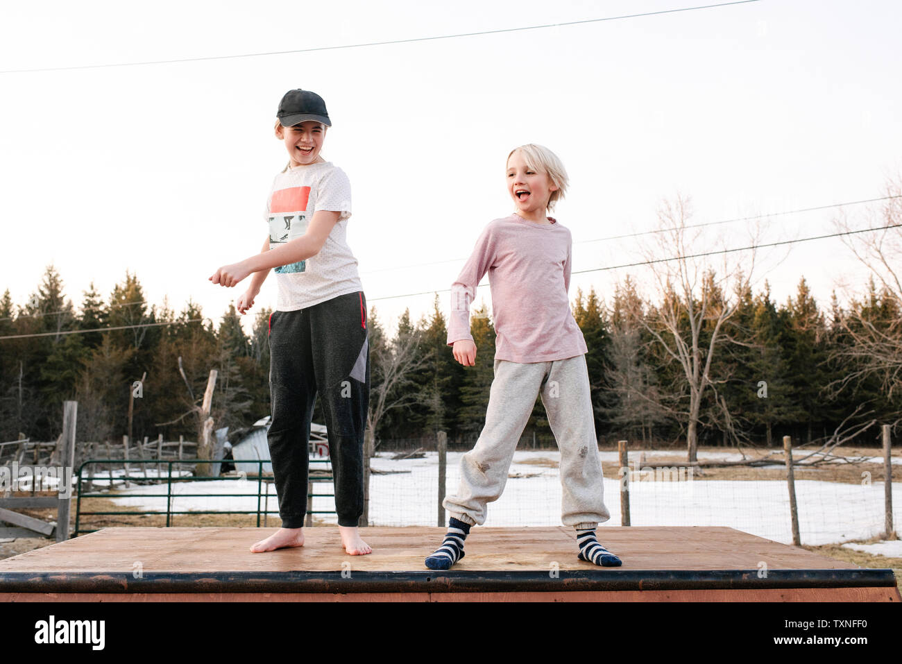 Junge und Schwester tanzen auf der Oberseite des ländlichen Betonplatte Stockfoto