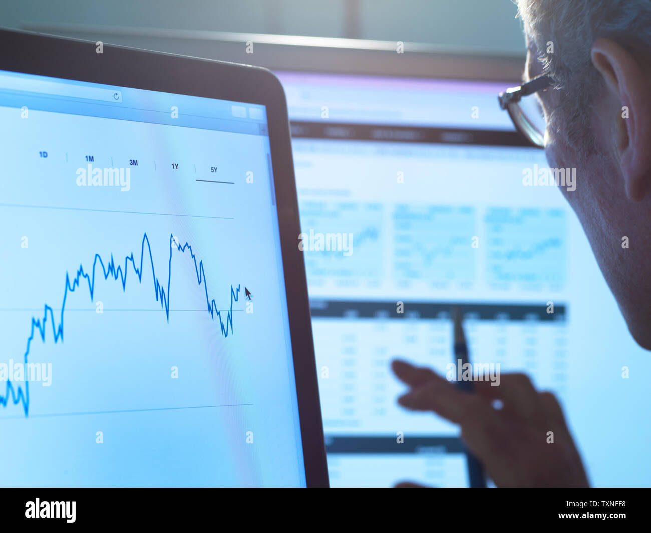Finanzdienstleistungen, Lager der Analyst untersucht das Aktienkurs Daten eines Unternehmens auf dem Computer Stockfoto