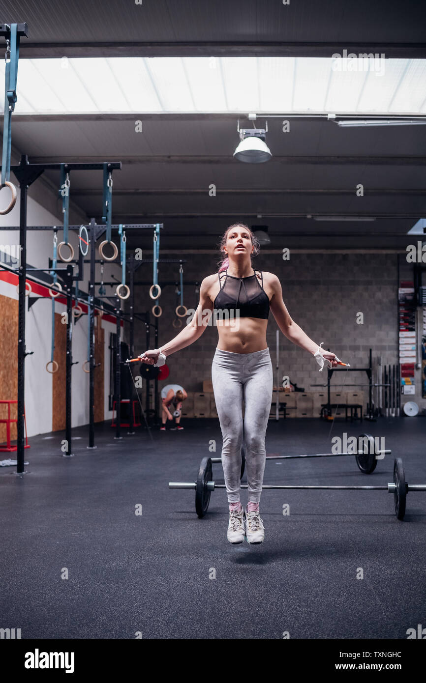 Junge Frau im Fitnessstudio überspringen Stockfoto